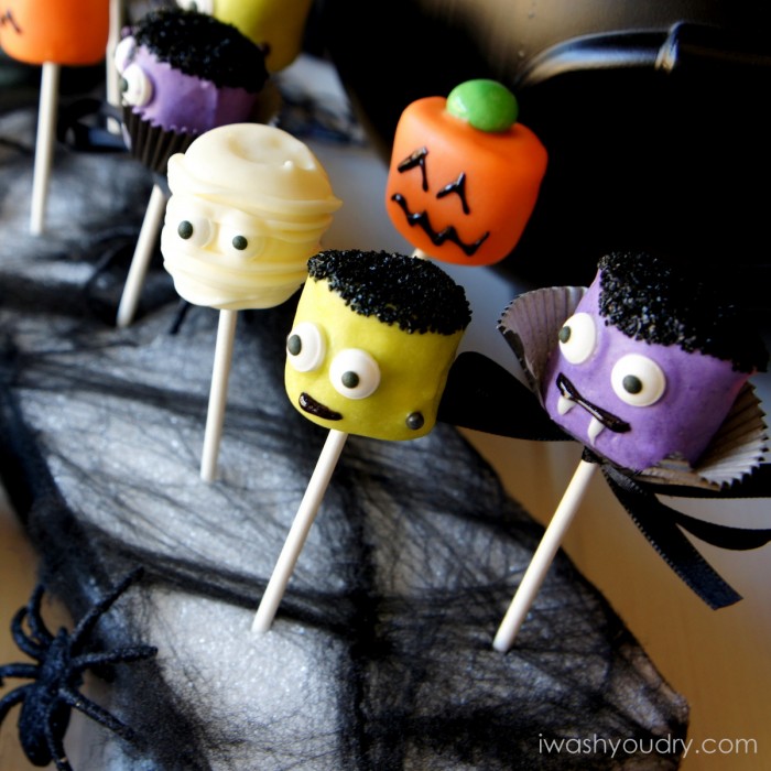 A Halloween themed display of Halloween themed Marshmallow pops - a mummy, a pumpkin, Frankenstein and a vampire