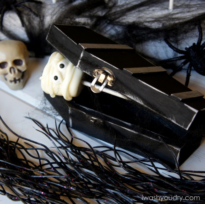 A display of a Mummy themed marshmallow pop in a closing coffin surrounded by other Halloween decorations