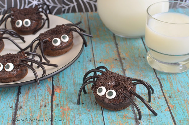 Chocolate Pumpkin Spider Doughnuts on a plate with a glass of milk on the side