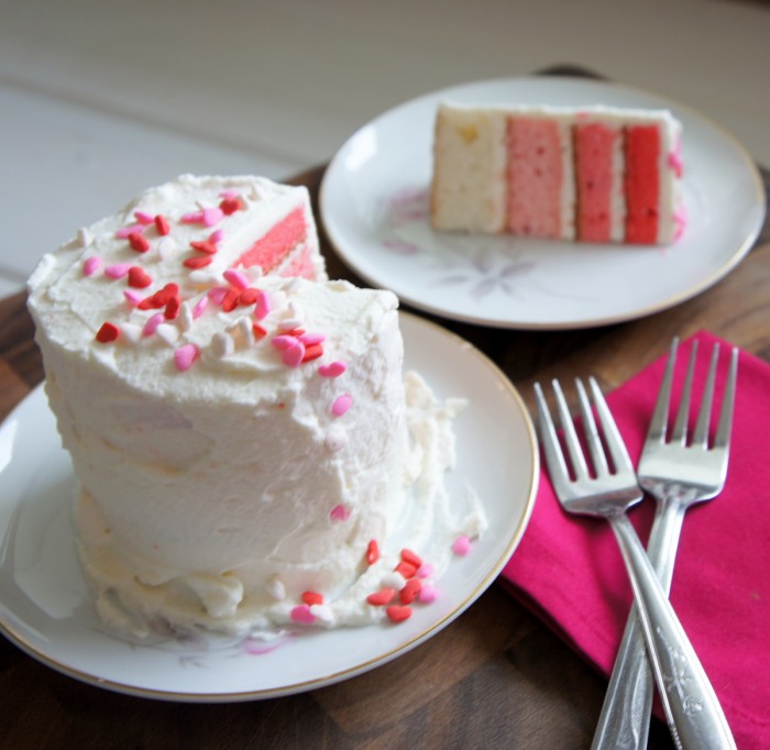 A white cake on a plate with a slice removed and next to it a second plate with the removed slice.