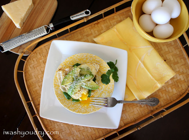 A plate of with an open egg sandwich with avocado slices on top