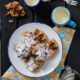 A plate of waffle cookies on a table next to a mug of milk