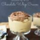 A clear glass dessert cup with Peanut Butter Pudding topped with chocolate whip cream