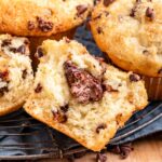 Half of a baked nutella chocolate chip muffin on blue dish towel.