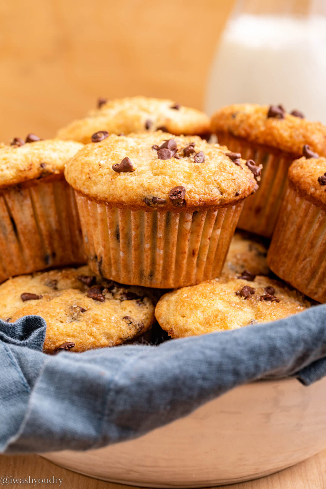 Pile of baked Nutella Chocolate Chip Muffins on blue dish towel. 