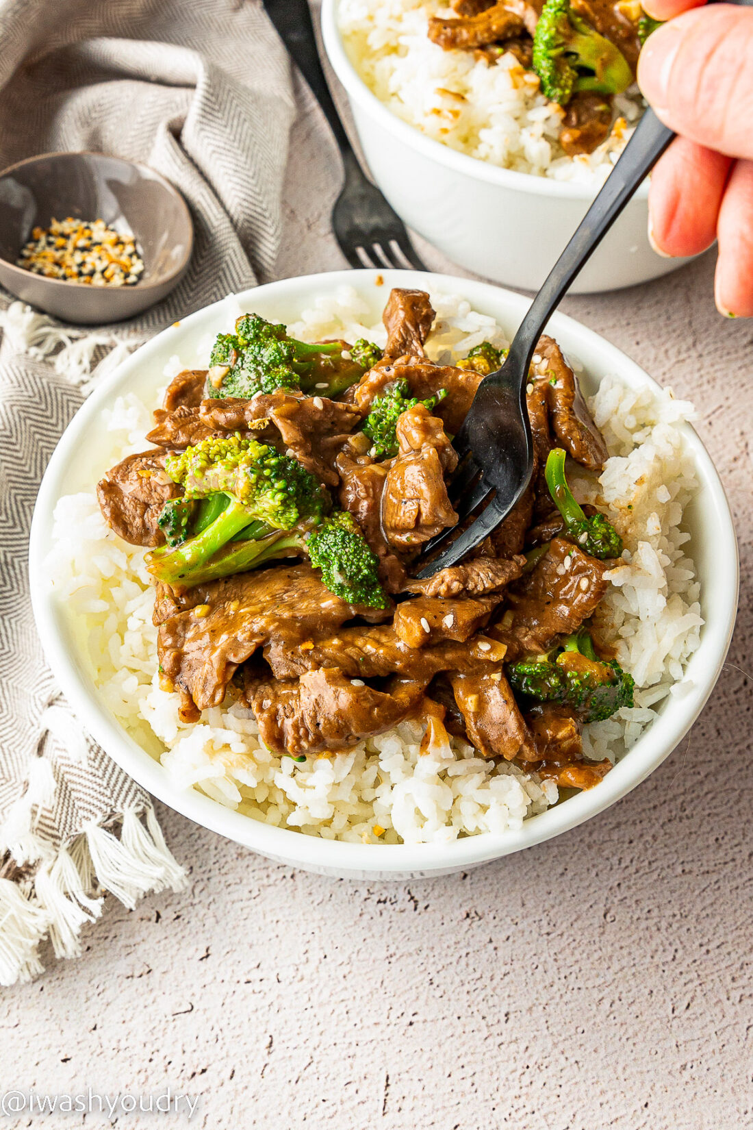 spoon with beef and broccoli and rice in bowl