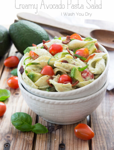 A bowl of salad, with pasta, avocado and tomatoes