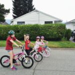 Four kids in the road on bikes riding