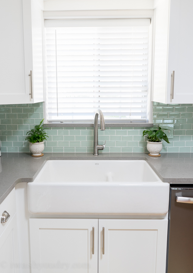 My dream kitchen includes this apron front farm sink with a touchless faucet! Love the backsplash and grey countertops as well. The whole kitchen looks awesome. 