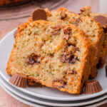 Slices of Chocolate Peanut Butter Cup Zucchini Bread on white plates.