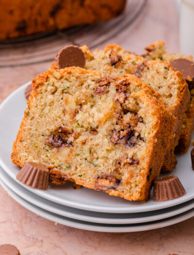 Slices of Chocolate Peanut Butter Cup Zucchini Bread on white plates.