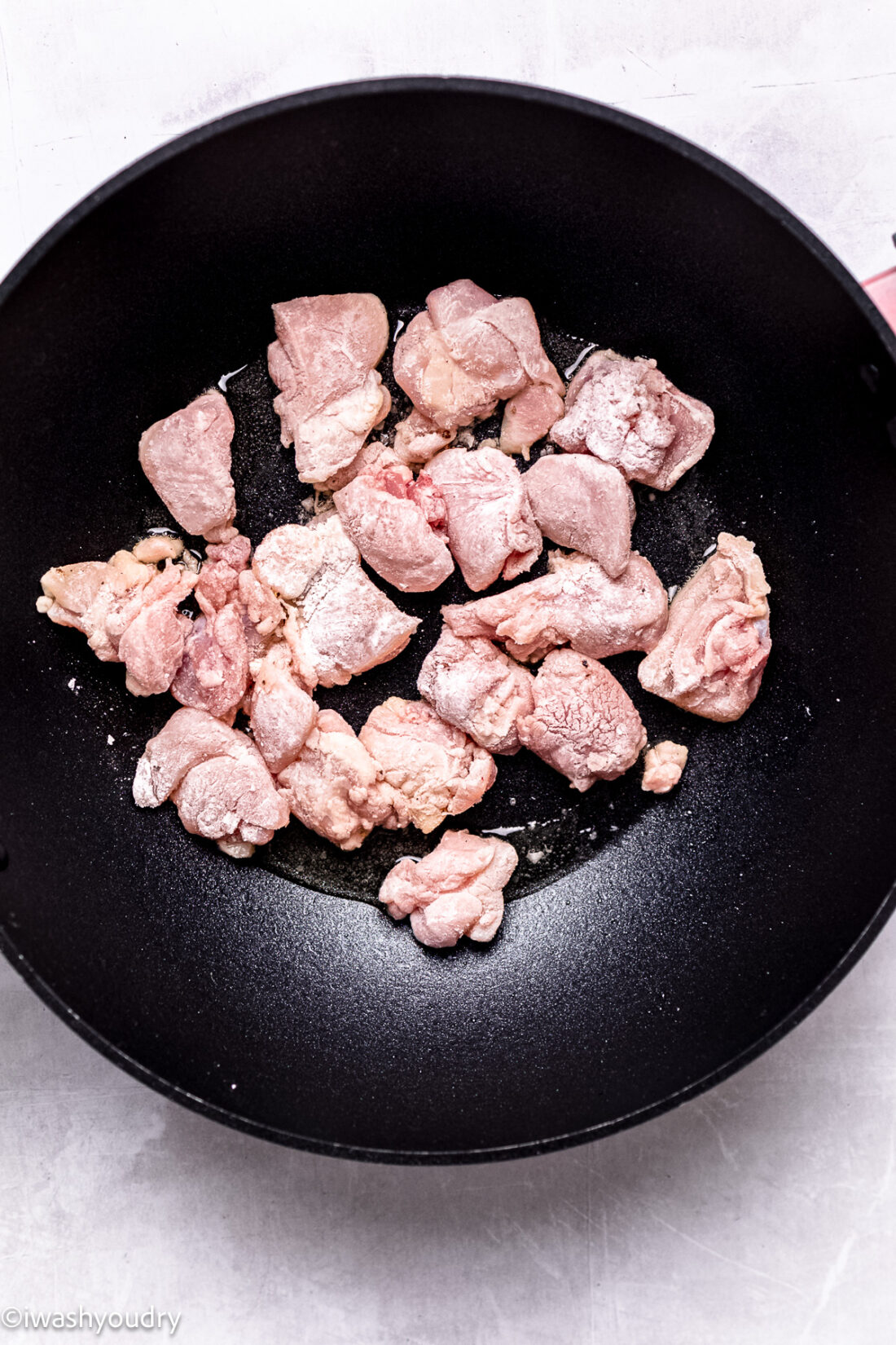 Raw chicken in black pan. 