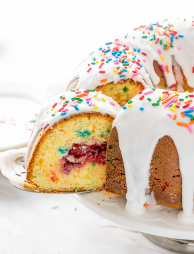 This Cherry Surprise Cake is a moist funfetti cake that's filled with cherry pie filling! So fun and so delicious, my whole family loved it!