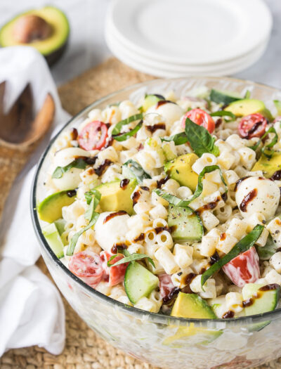 This Avocado Caprese Pasta Salad is a cold pasta salad that is perfect for parties and bbq's! Full of fresh veggies and creamy pasta!