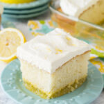 A square of lemon cake on a plate with white frosting