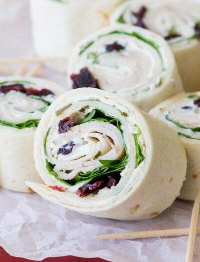 These Turkey Cranberry Pinwheels are filled with a creamy cream cheese, spinach, turkey and cranberries! Perfect for lunch or appetizers!