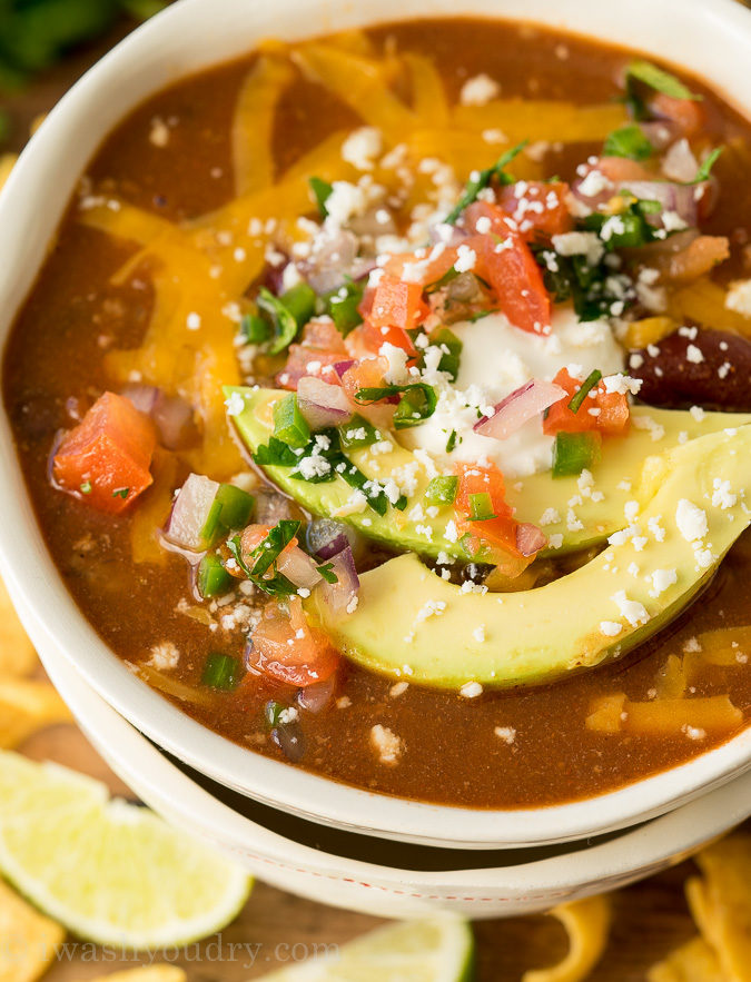 bowl of soup with ground beef and beans with cheese on top