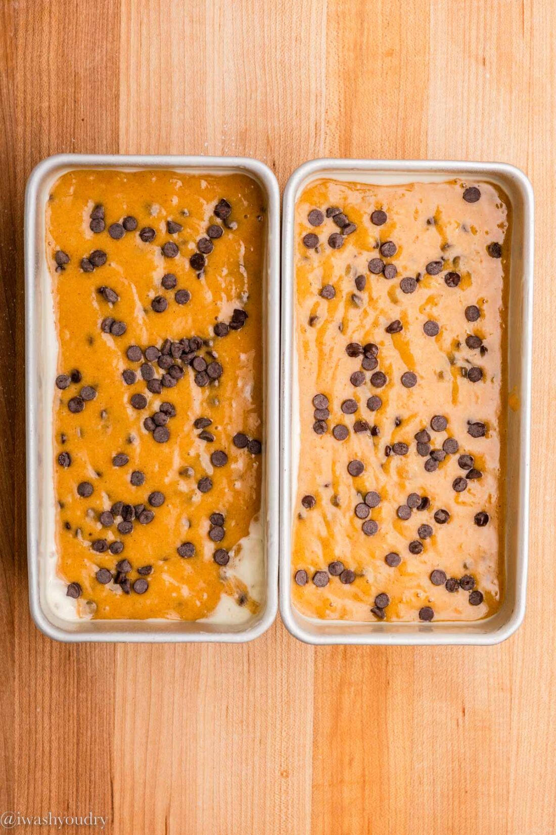 Raw pumpkin chocolate chip batter in 2 metal baking pans. 