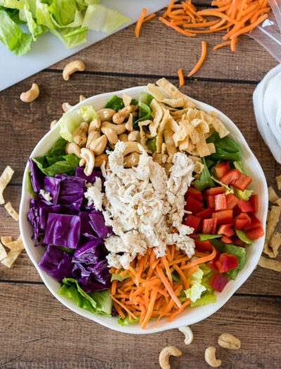 By placing the colorful ingredients around the bowl it makes it more attractive and fun to eat! Your kids will LOVE this Asian Chicken Salad!