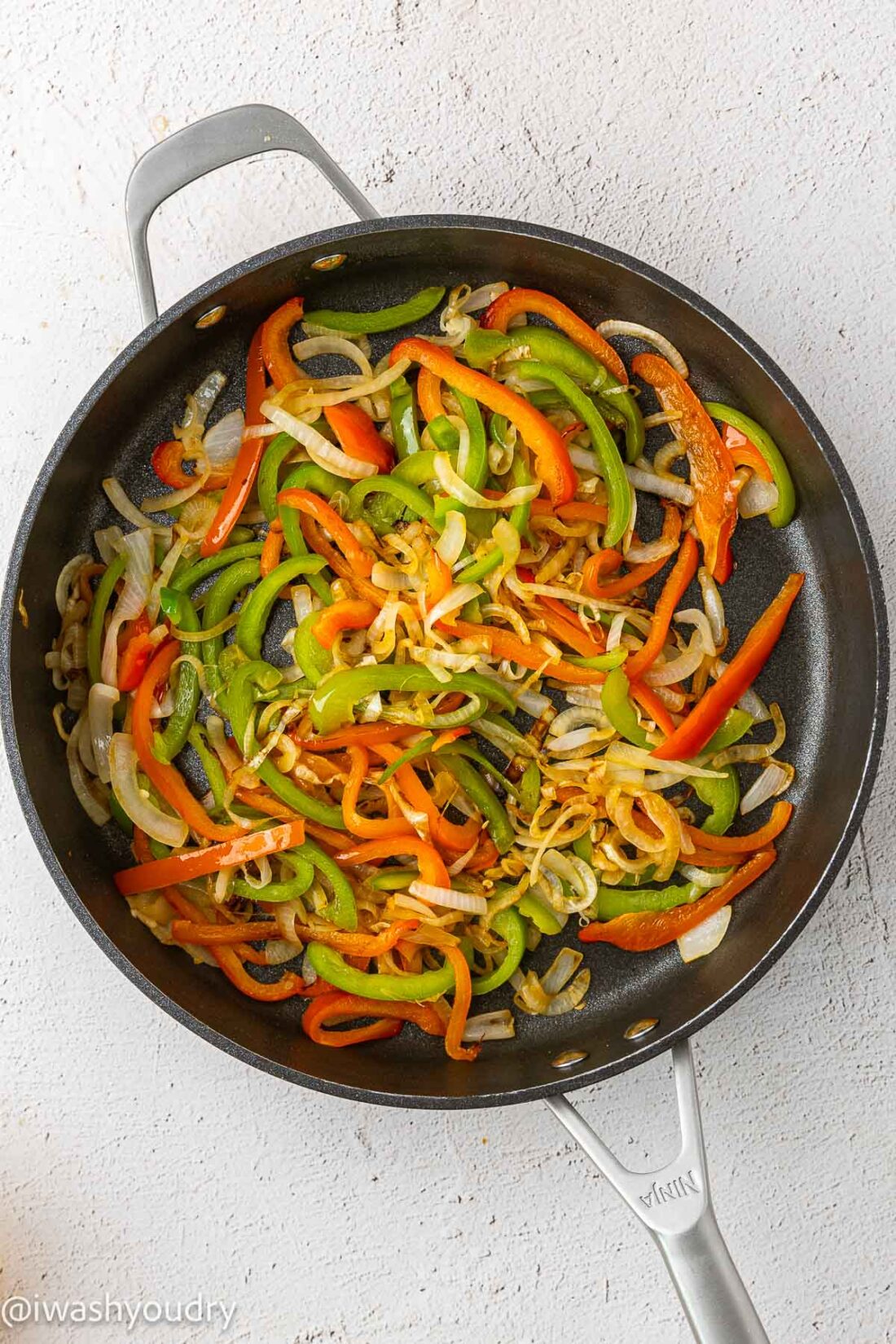 charred peppers and onions in large black skillet.