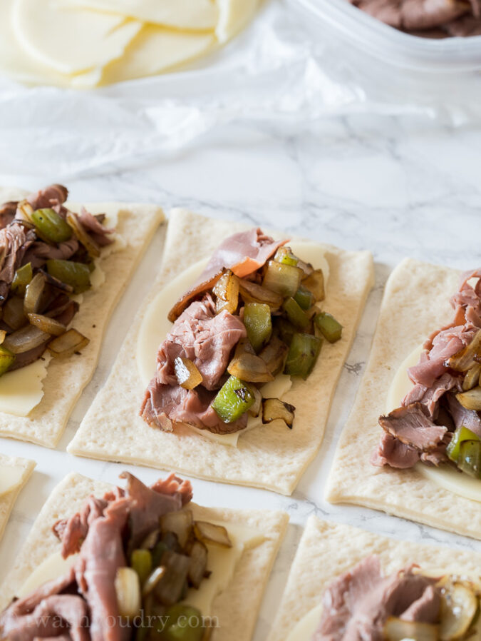 Top each pizza dough slice with some provolone cheese, roast beef and sautéed peppers and onions.