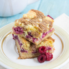 Two bars of Gooey Raspberry Coffee Cake stacked on top of each other on a plate