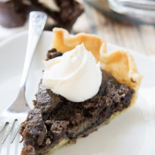 A piece of Ding Dong Pie topped with whipped cream displayed on a white plate