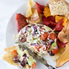 A plate of food, with Hummus and chips