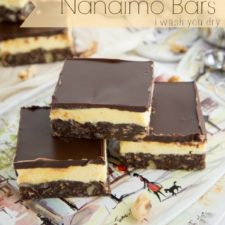 Three Nanaimo bars stylishly stacked on a plate for display