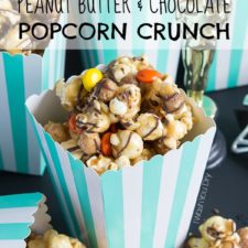 Peanut butter and chocolate popcorn displayed on a table in a white and turquoise stripped container