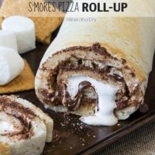 A close up of a S'more's Pizza Roll Up with a slice made from it next to it and gooey marshmallow and chocolate dripping out