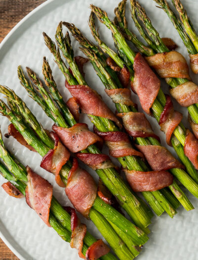 OMG! This Bacon Wrapped Asparagus Recipe is seriously so delicious! We served this easy side dish with steaks and mashed potatoes and it was a total hit!