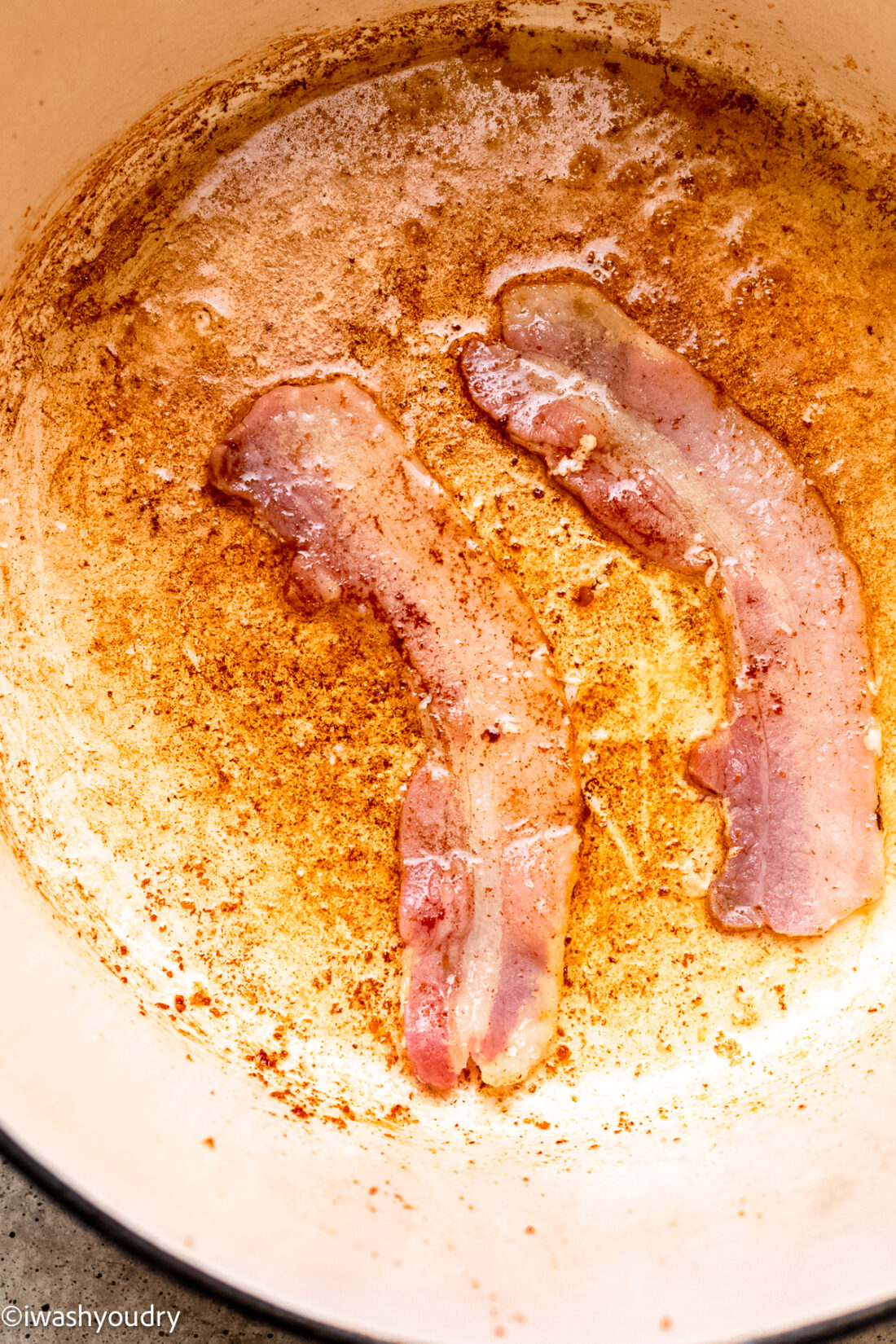 crispy bacon in dutch oven with grease around.