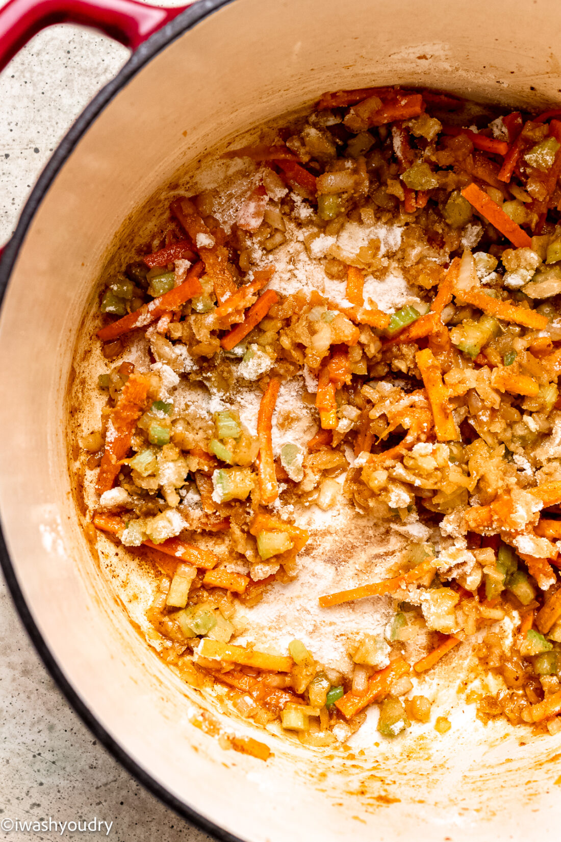 flour sprinkled in pot over vegetables to create roux.