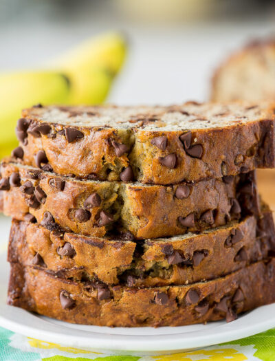 A piece of chocolate cake on a plate, with Banana and Bread