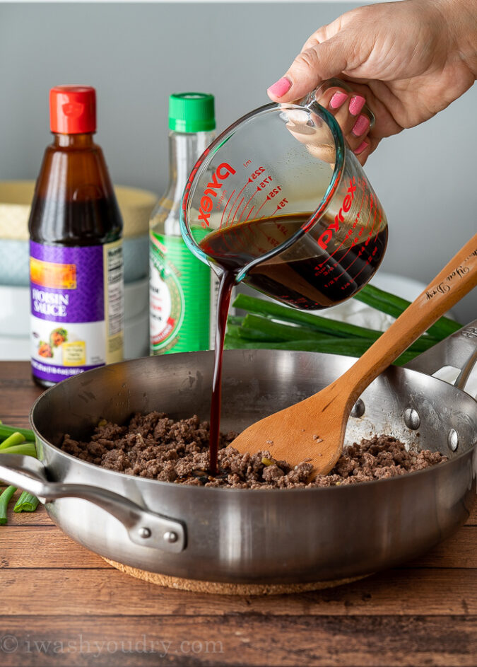 pouring sauce in pan with ground beef.