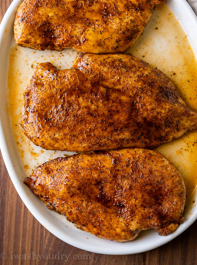 White plate with oven baked chicken and juices