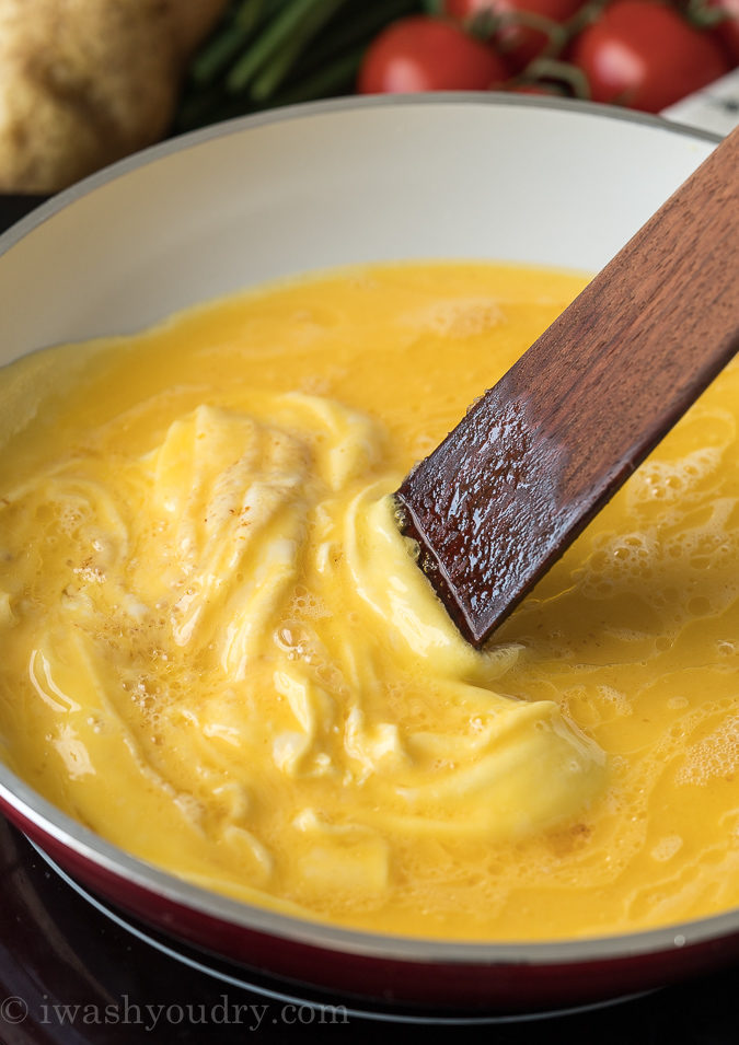 Gently push the eggs to release the bottom layer of cooked eggs from the pan.