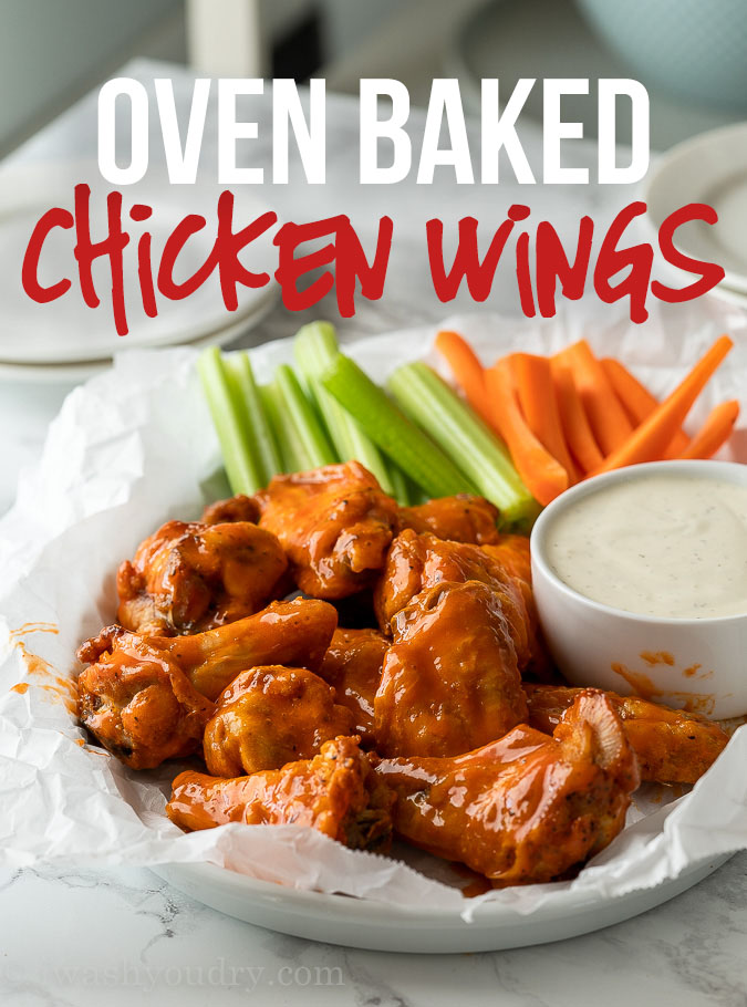 Crispy Oven Baked Chicken Wings covered in buffalo sauce along with celery and carrot sticks.