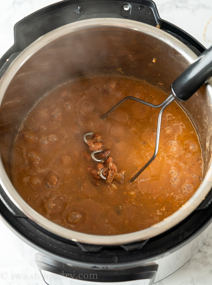 Mash the cooked beans with a potato masher to get the desired consistency of refried beans you would like.