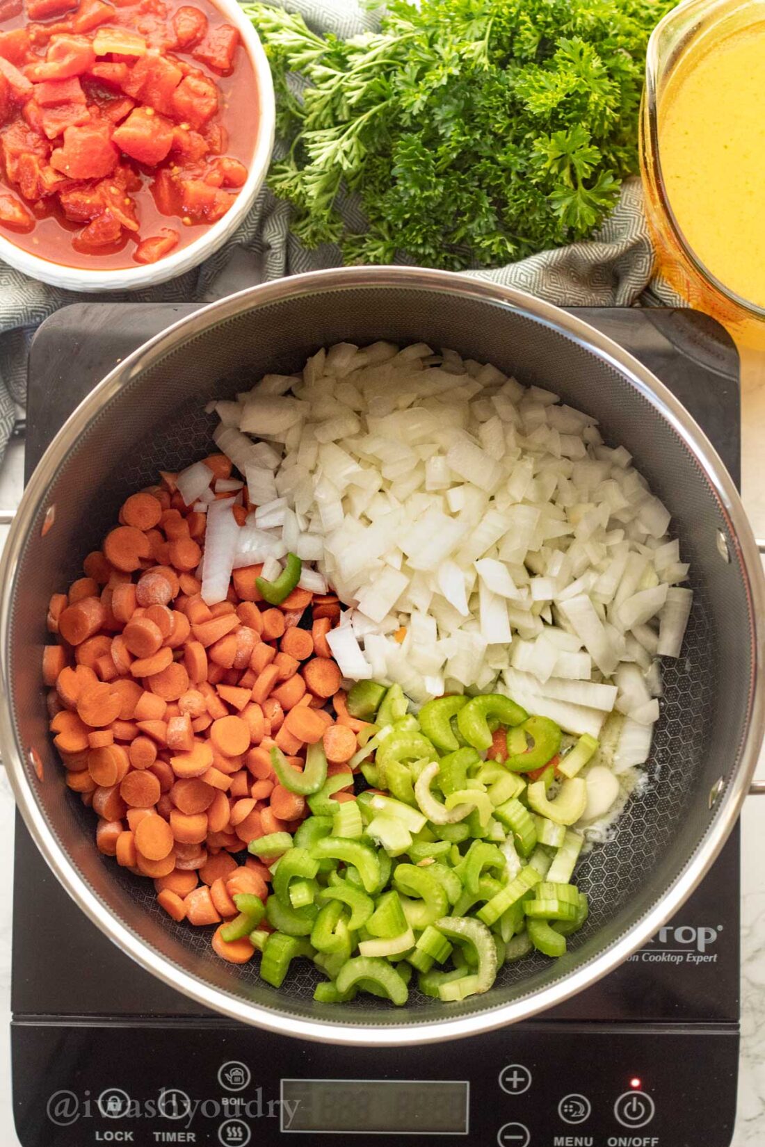 pot filled with carrots, onions and celery.