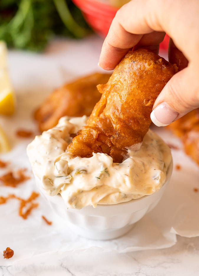 Fried fish dipped into tartar sauce