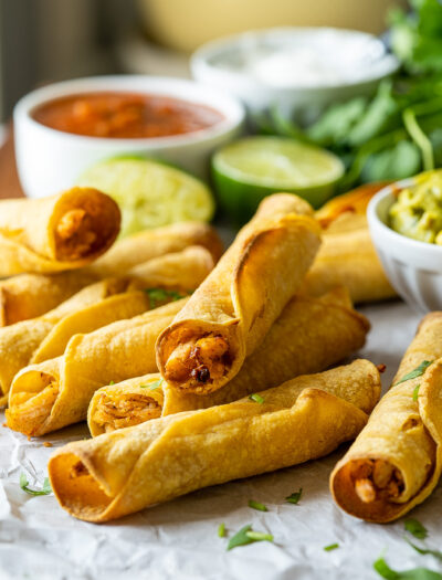 Plate full of crispy chicken taquitos