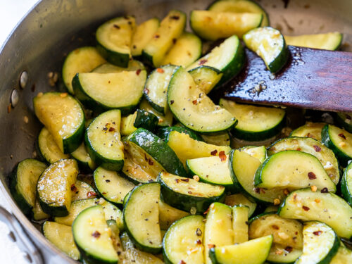 Sautéed Zucchini in a skillet with red pepper flakes.