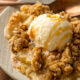 dessert on plate with apples and vanilla ice cream