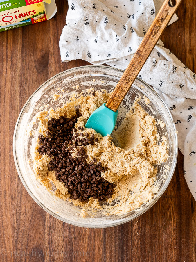 adding mini chocolate chips to cookie dough