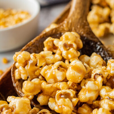 caramel corn in wooden spoon in metal pan.