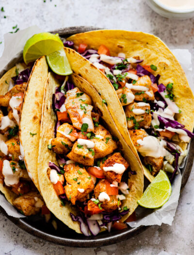 fish tacos on plate with limes