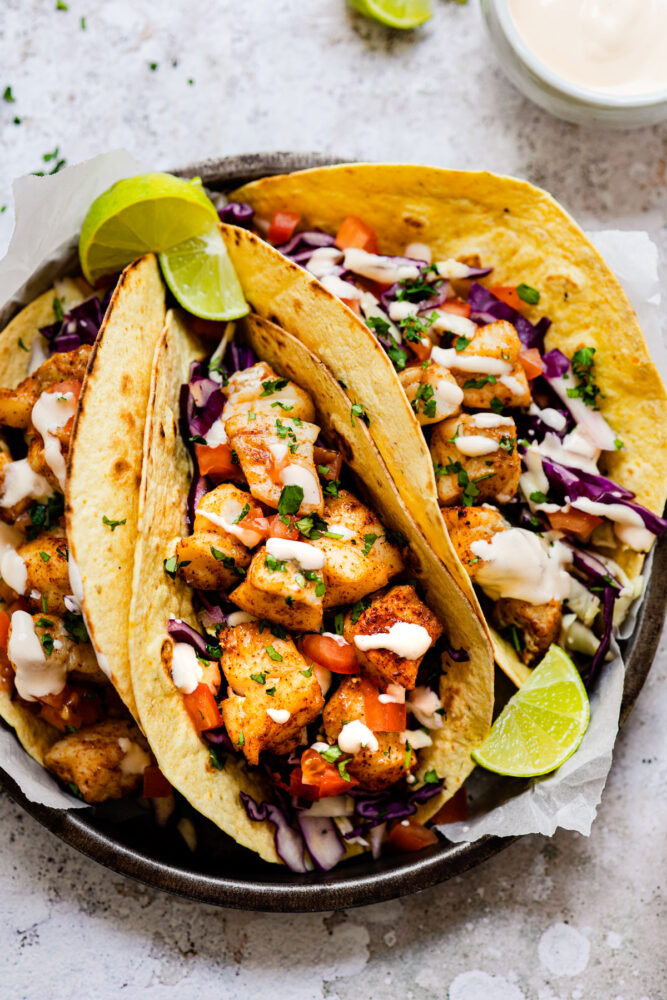 fish tacos on plate with limes