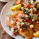 grilled salmon on white plate with greek salsa